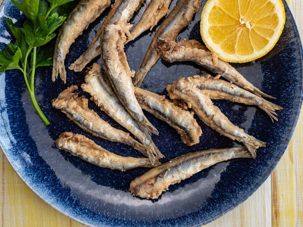 El azul resalta el dorado del pescado frito y evoca frescura marina.