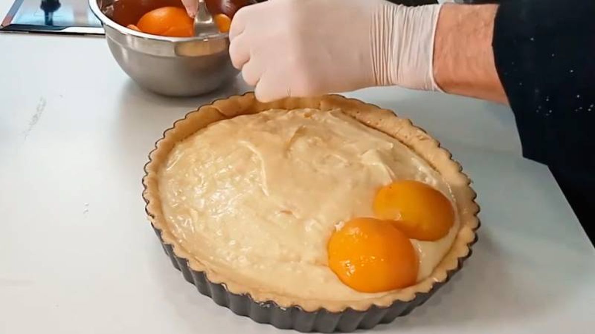 Pon los melocotones sobre la crema y cubre con masa