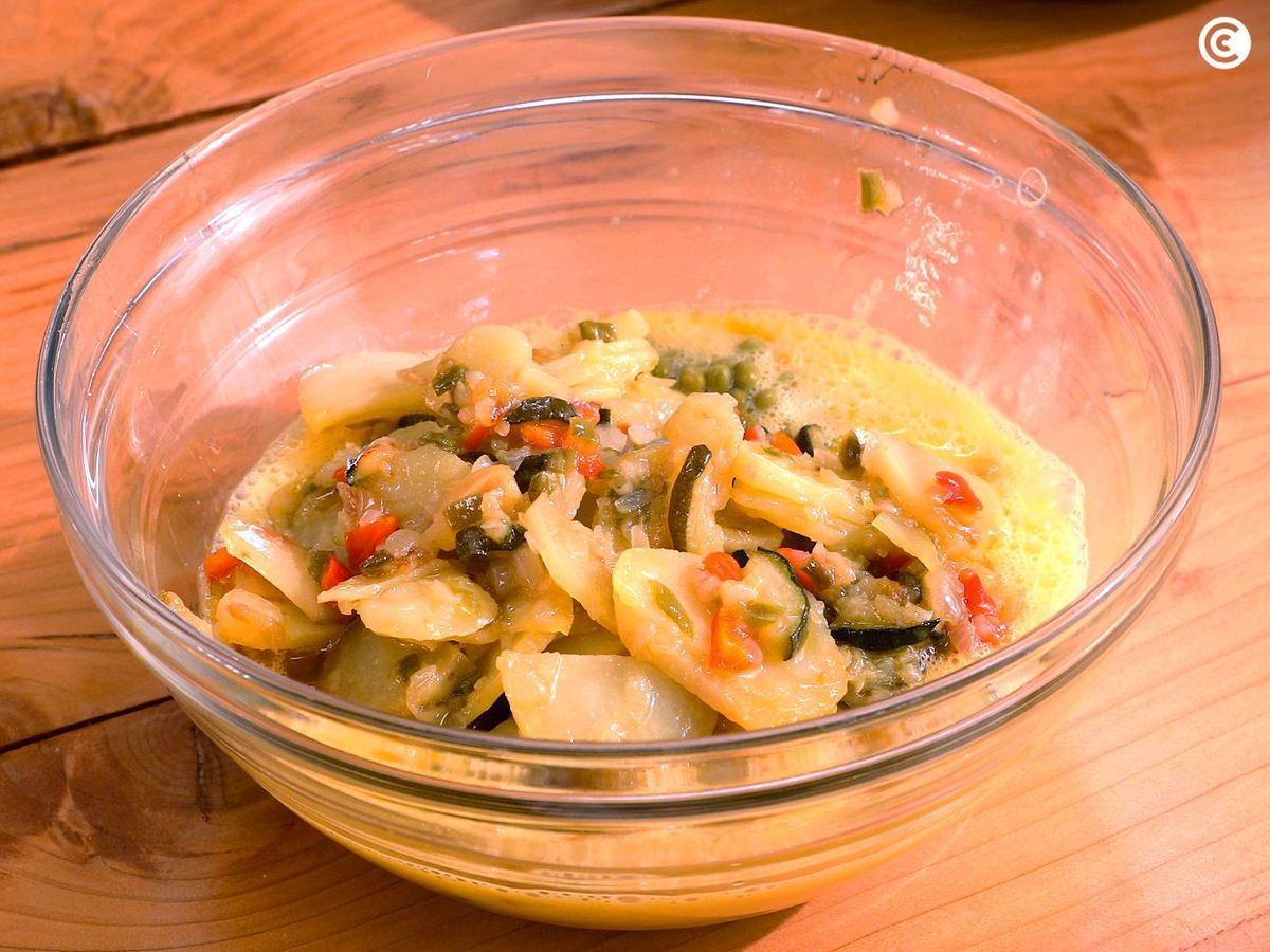 Mezclar las verduras con el huevo batido para la tortilla paisana