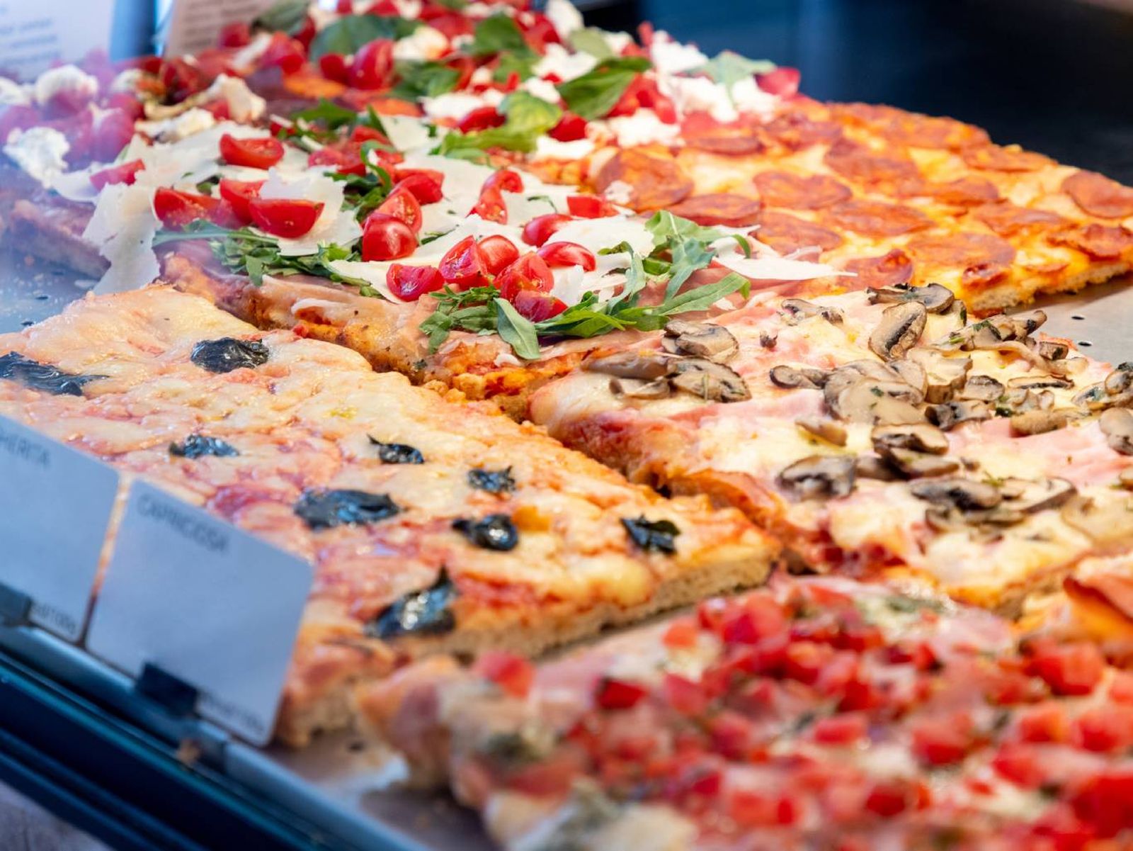 La clásica pizza al taglio romana: crujiente, servida en porciones y perfecta para compartir.