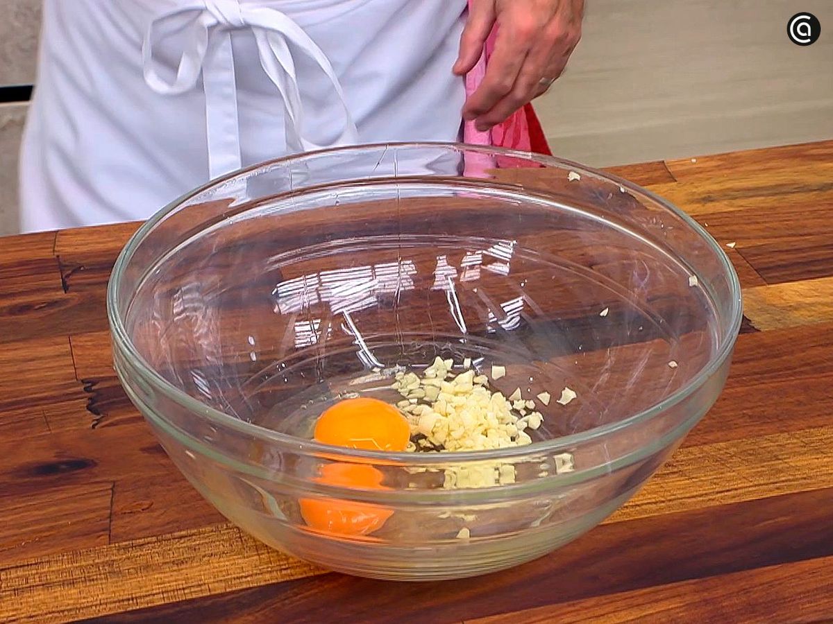 Batir los huevos con el ajo para empanar la milanesa napolitana