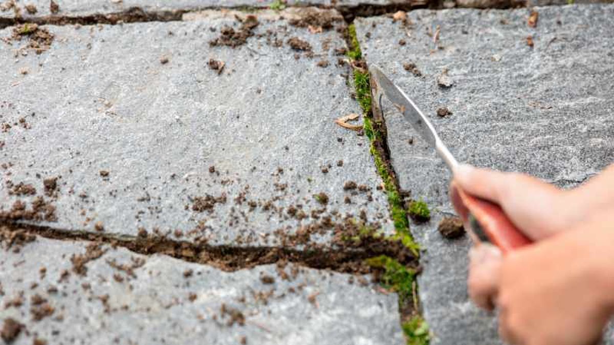 Persona limpia las juntas con un cuchillo