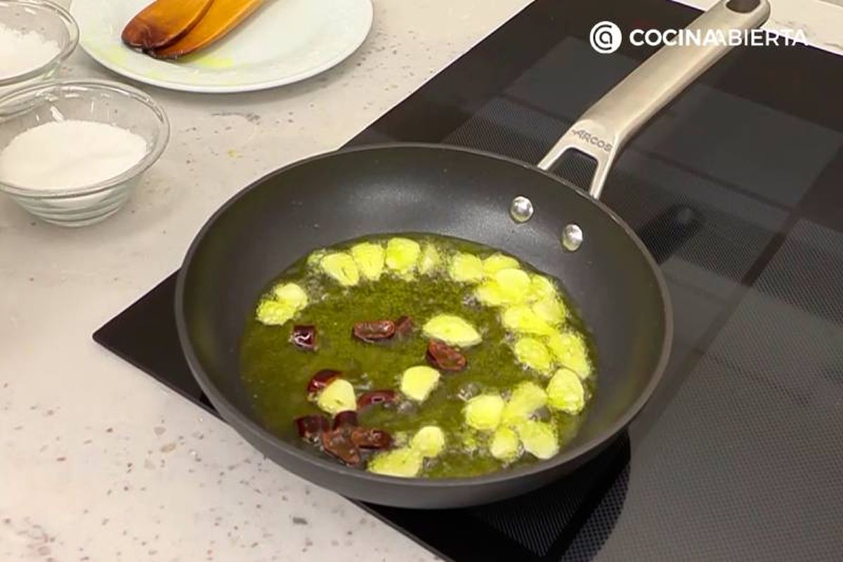 Elaboración de la receta de rape al horno con patatas - Cocina un refrito de ajo y guindilla