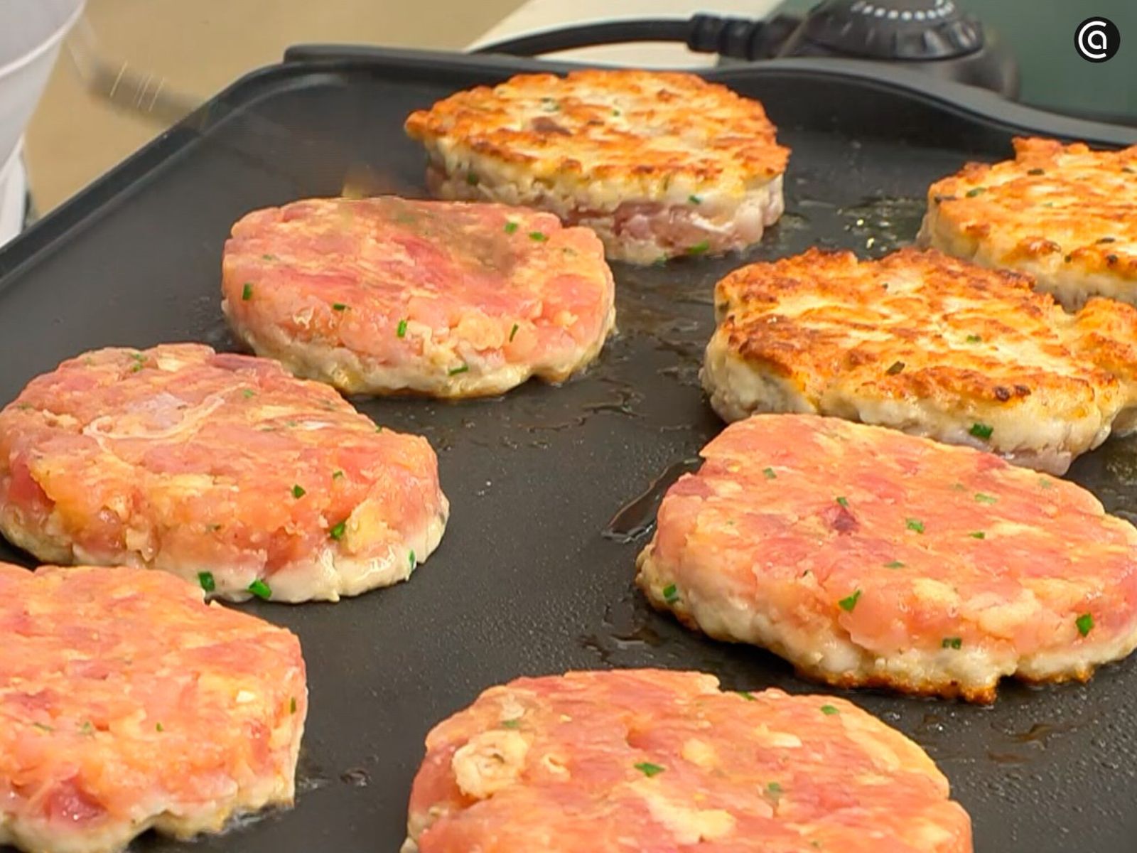 Cocina las hamburguesas sobre la plancha caliente Cocina las hamburguesas sobre la plancha caliente