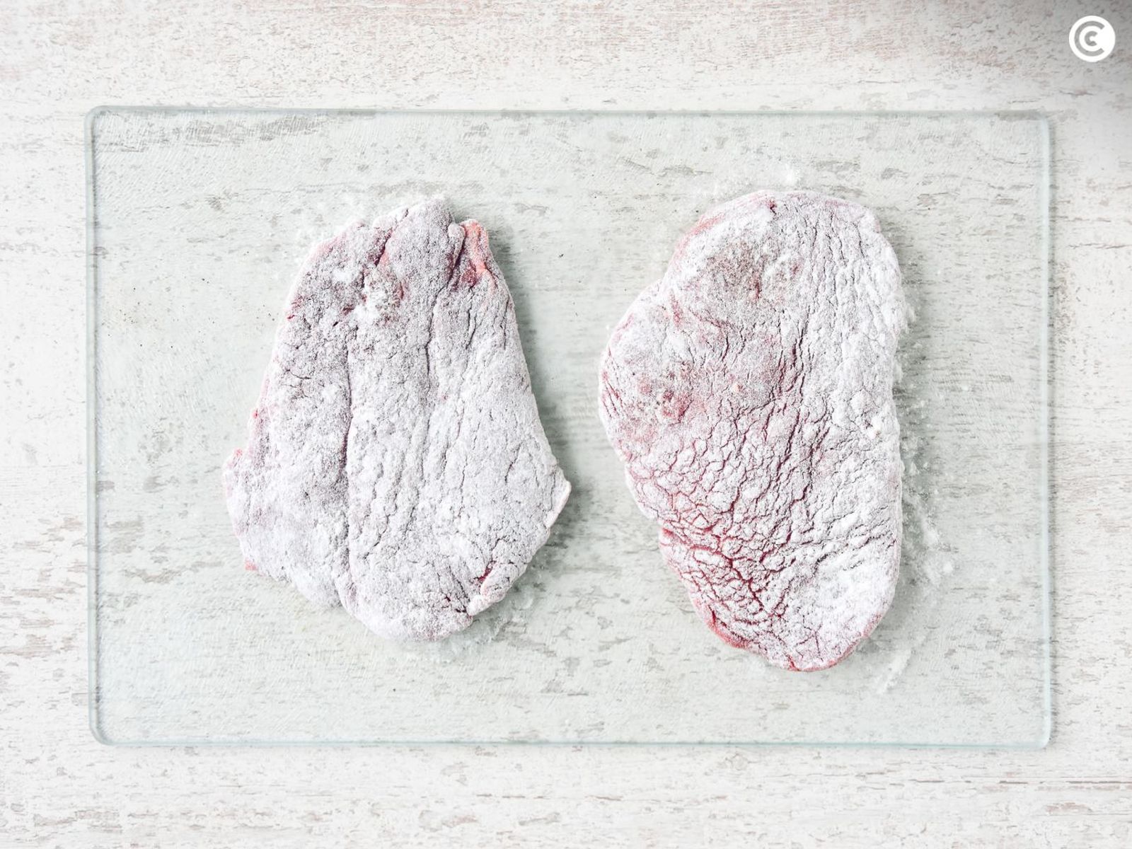 Enharinar los filetes de ternera para hacerlos empanados