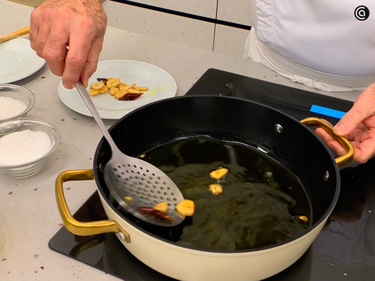 Sofríe los ajos junto con unas rodajas de guindilla y reserva