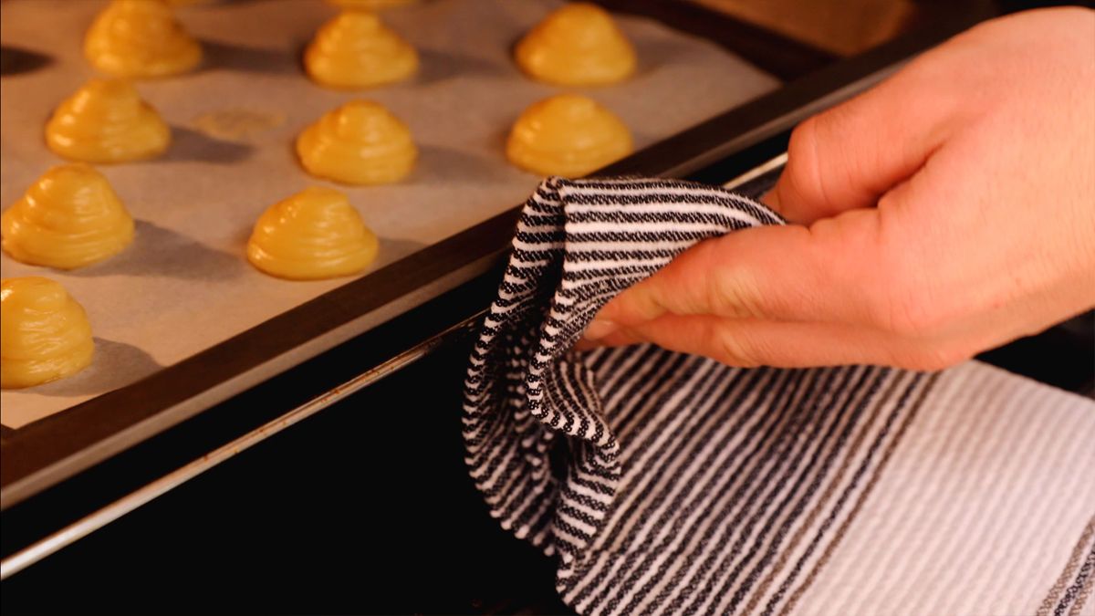 Hornea los profiteroles a 200ºC durante 10 minutos y luego baja la temperatura a 180ºC otros 10 minutos para obtener un acabado perfecto