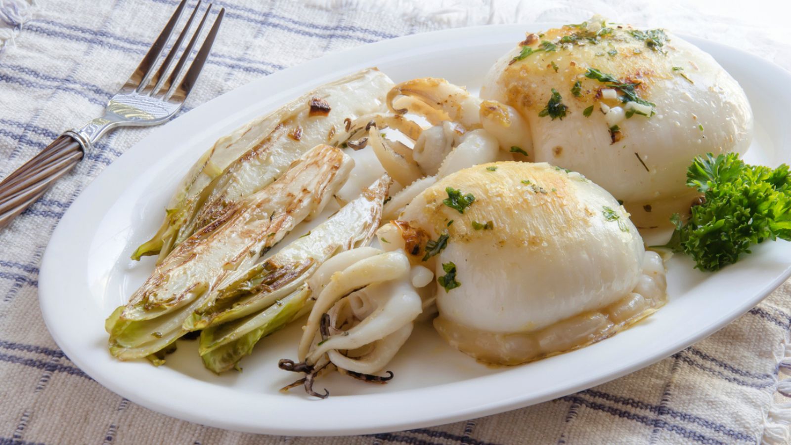 Sepia a la plancha acompañada de endivias asadas, una combinación fresca y ligera.