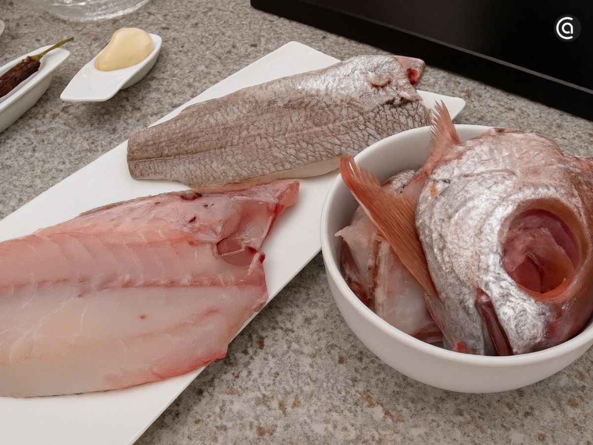 Lomos de besugo ya limpios y los restos del pescado reservados para preparar un caldo corto y concentrado.