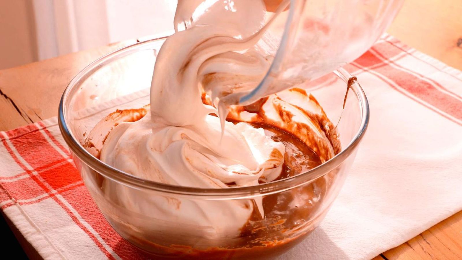 Vierte las claras montadas sobre el chocolate y mezcla suavemente para mantener la esponjosidad Vierte las claras montadas sobre el chocolate y mezcla suavemente para mantener la esponjosidad