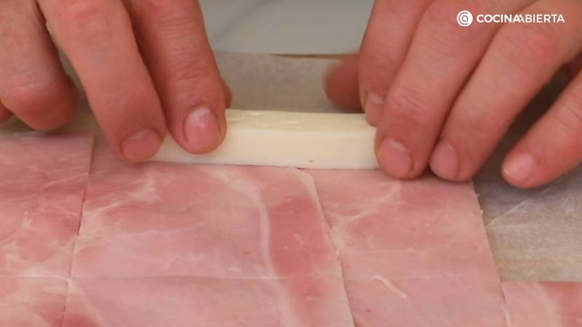 Coloca una tira de queso en el extremo de cada rectángulo y enrolla