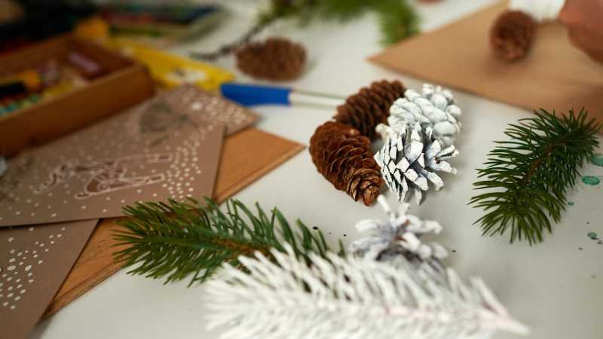 Pintar piñas de blanco para hacer muñecos de nieve.