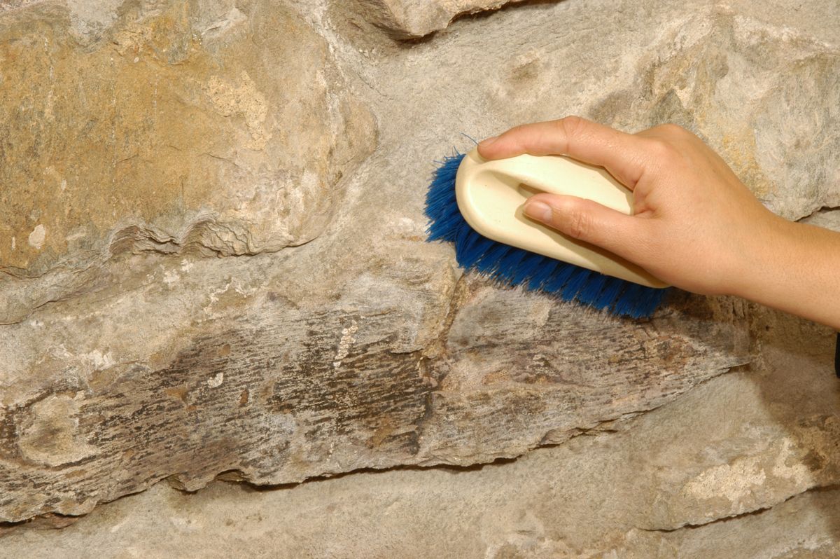 Limpiar pared de ladrillo con un cepillo