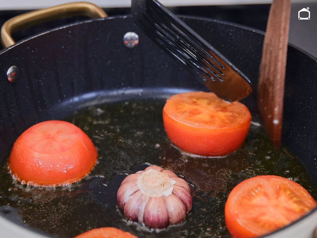 Dora el tomate y el ajo para el arroz al horno con bacalao