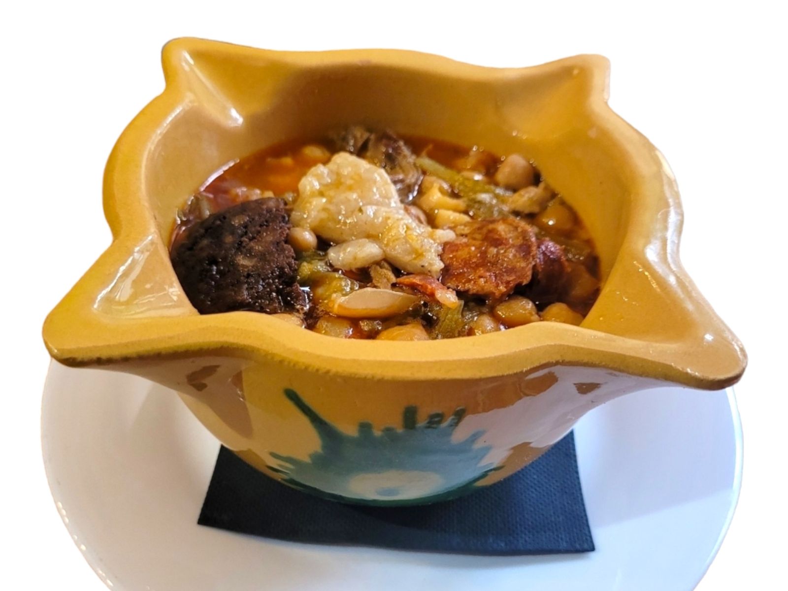 Uno de sus grandes guisos, la berza jerezana: garbanzos, habichuelas y pringá servidos en cazuela, puro sabor de Jerez.