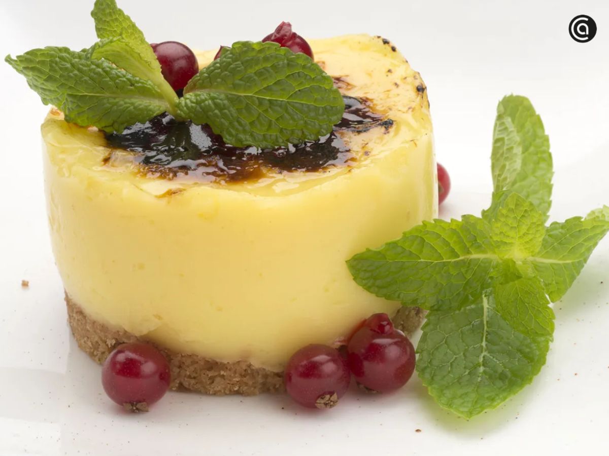 Base de galleta y crema de limón con un toque caramelizado, decorada con menta.