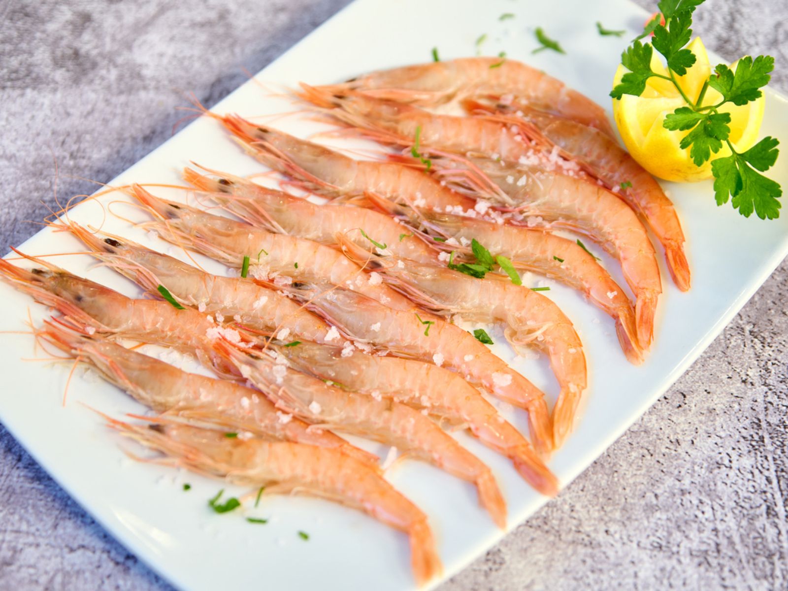 Gamba blanca de Huelva cocida y emplatada con sal gorda y limón. Su carne suave y sabor sutil la convierten en un clásico de la gastronomía andaluza. Gamba blanca de Huelva cocida y emplatada con sal gorda y limón. Su carne suave y sabor sutil la convierten en un clásico de la gastronomía andaluza.