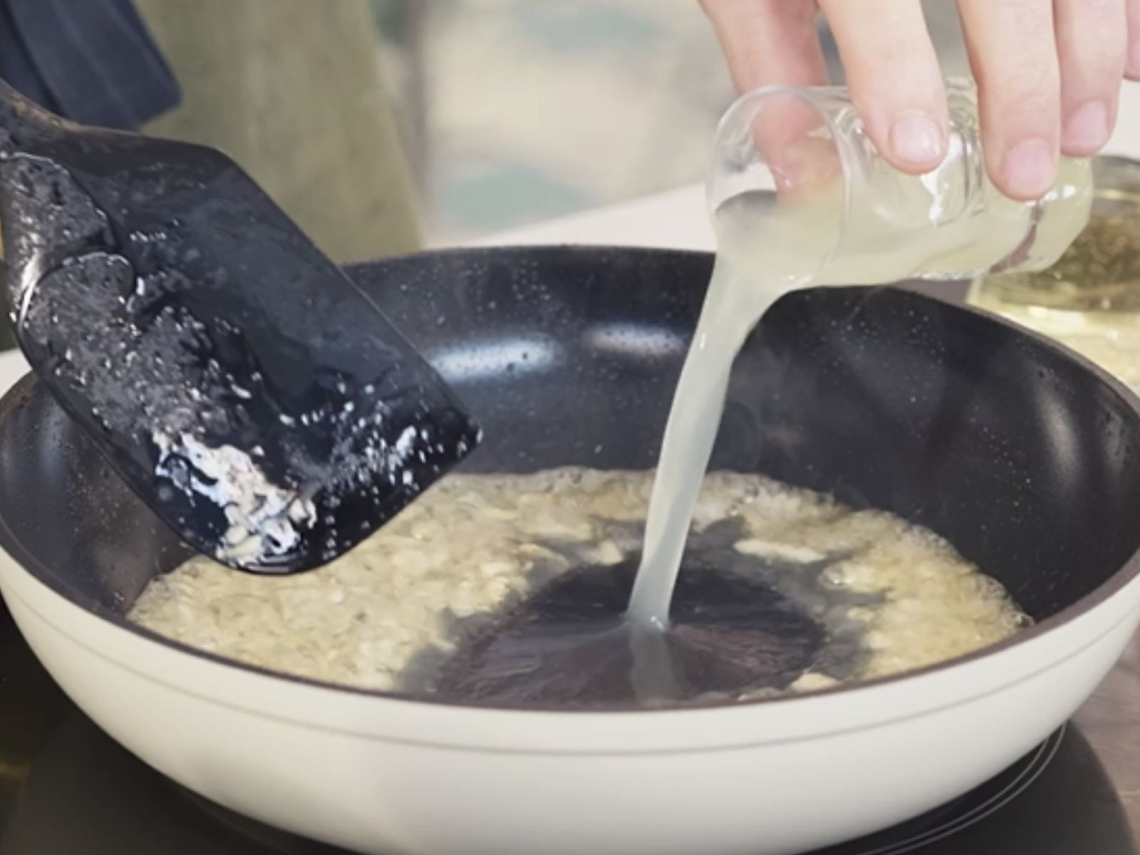 Añade el zumo de limón y el vino blanco al sofrito de ajos para crear una salsa ligera y aromática.