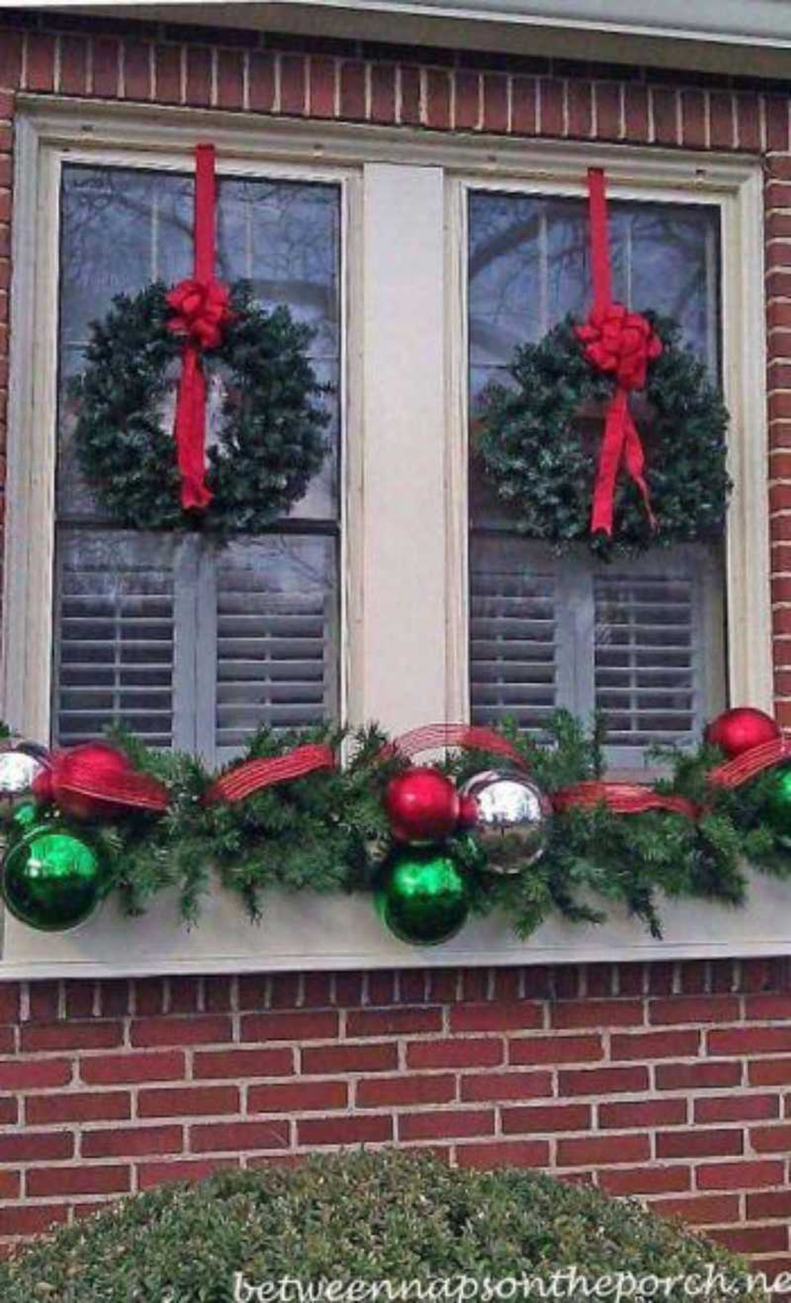 Ventana decorada con dos coronas navideñas en los laterales. Ventana decorada con dos coronas navideñas en los laterales.