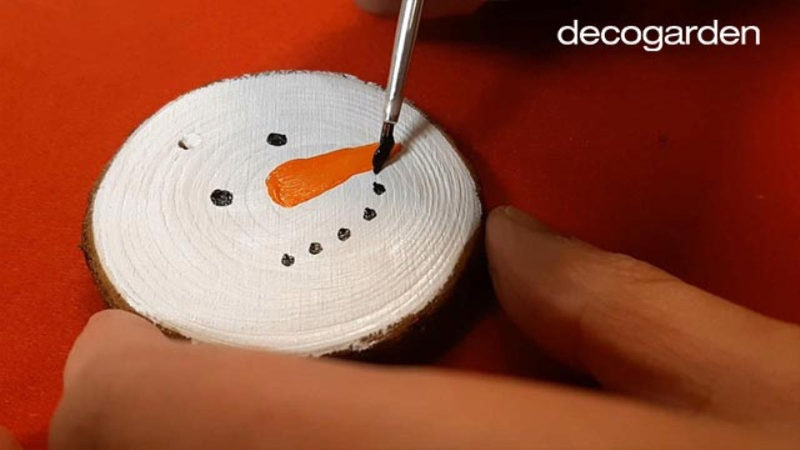 Pintar un muñeco de nieve navideño en un disco de madera. Pintar un muñeco de nieve navideño en un disco de madera.