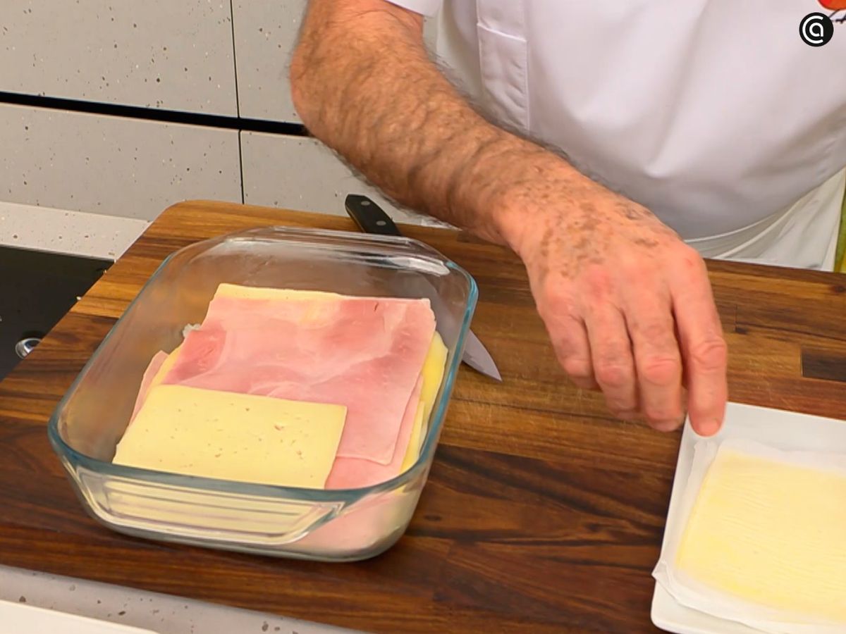 Pon un poco de la bechamel en una fuente y coloca por encima jamón y queso en lonchas