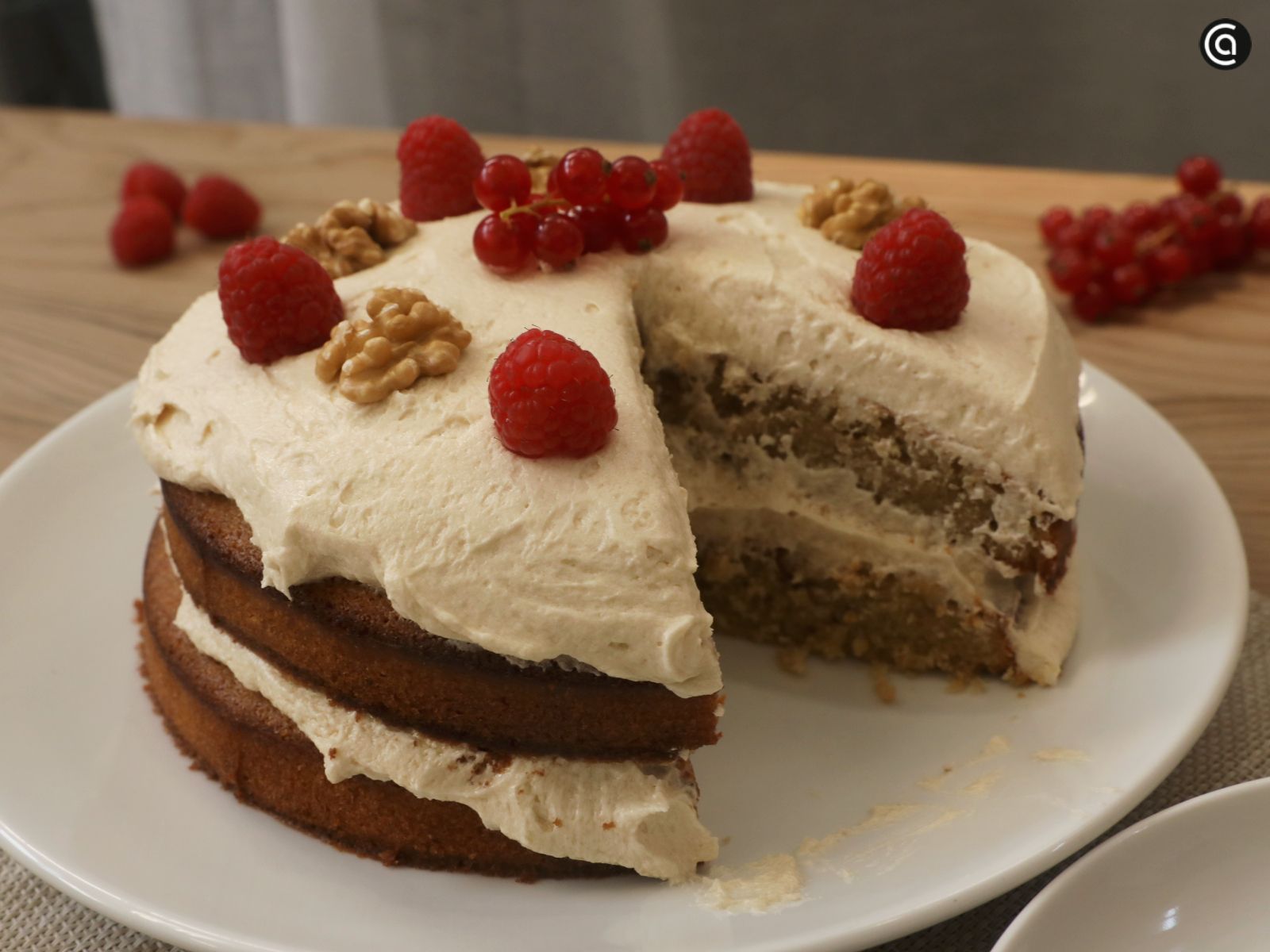 Tarta de café con nueces decorada con fresas y frutos rojos