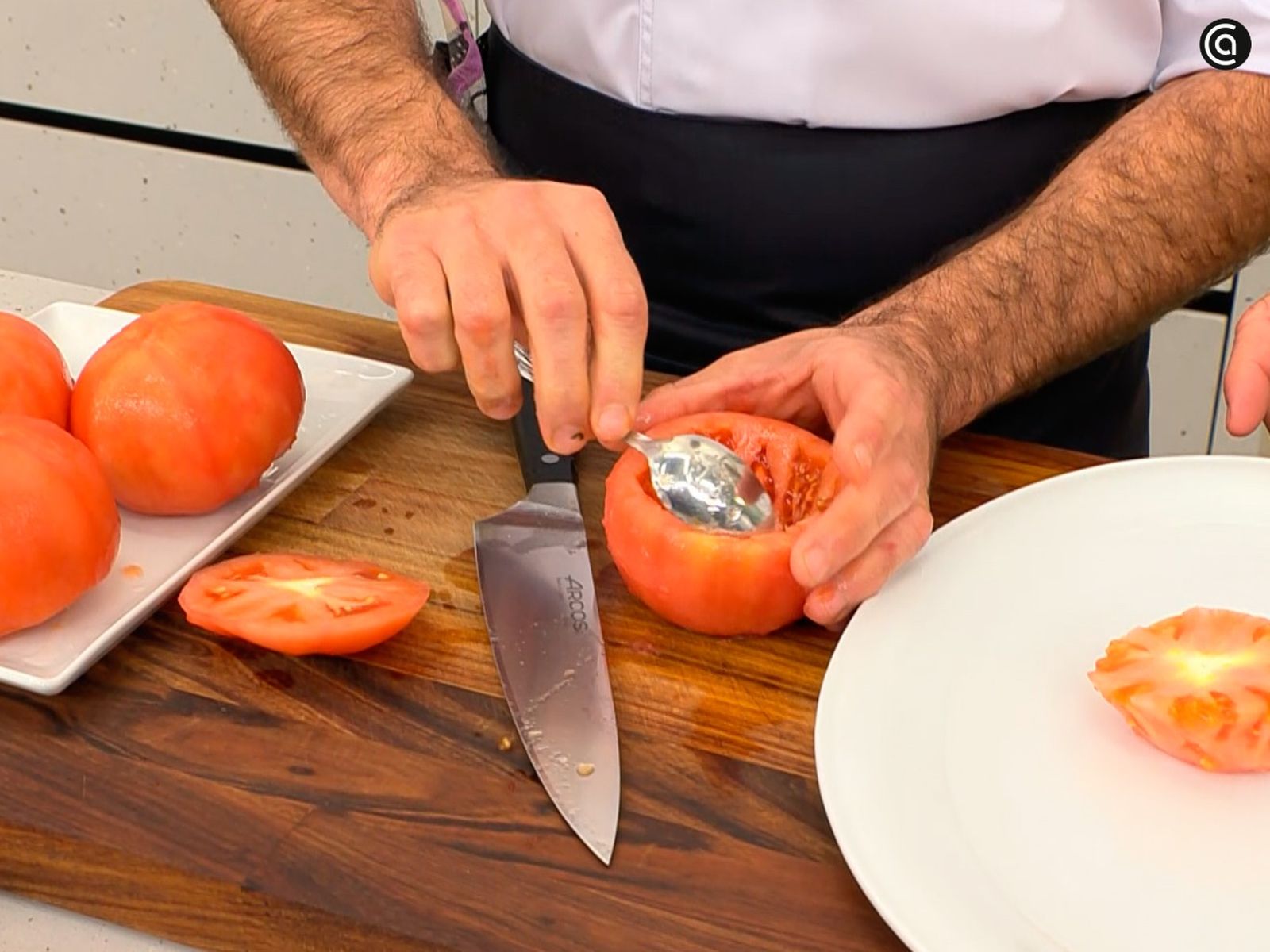 Corta y vacía los tomates con la ayuda de una cuchara Corta y vacía los tomates con la ayuda de una cuchara