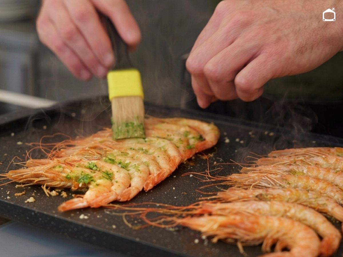 Unta la mitad de las gambas con el majado de ajo y perejil