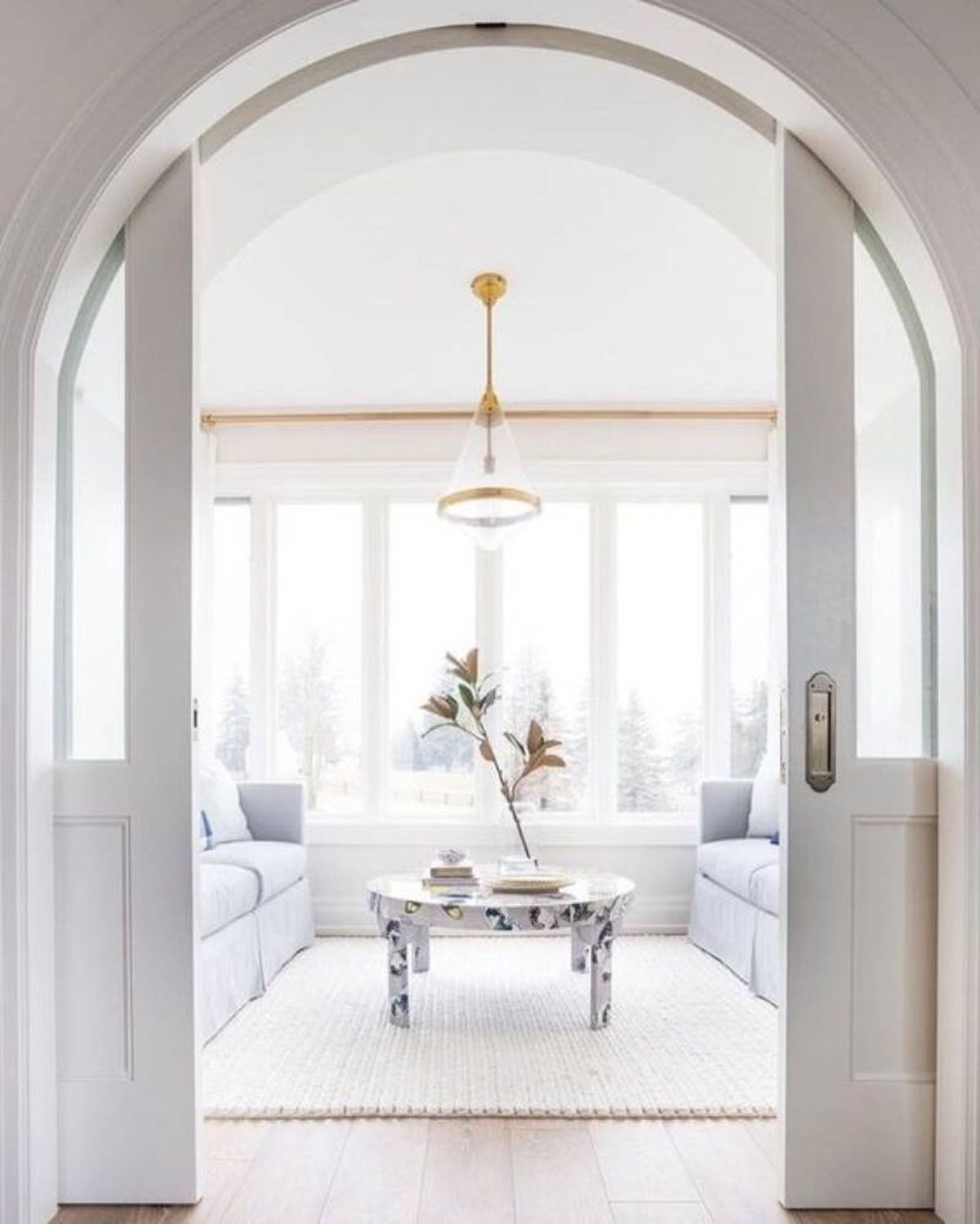 Salón con puertas correderas y arco decorativo.