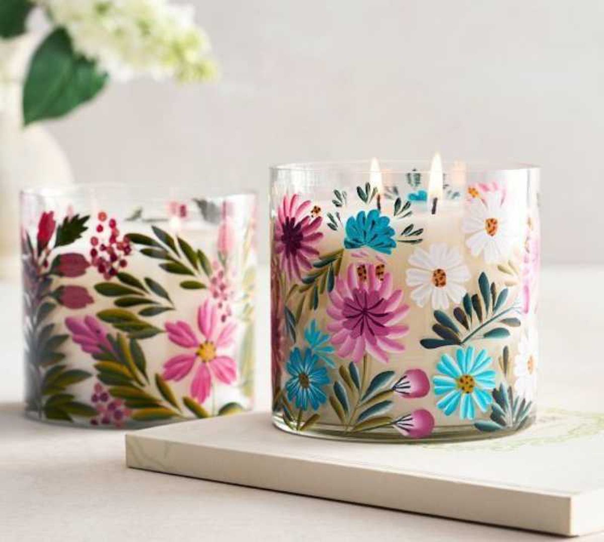Portavelas de cristal con flores pintadas.