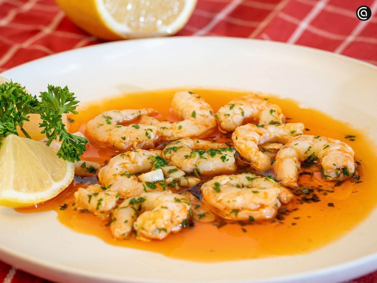 Decora las gambas al ajillo con rodajas de limón y perejil fresco