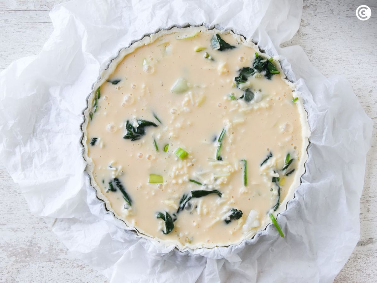 Quiche de espinacas en el molde lista para hornear