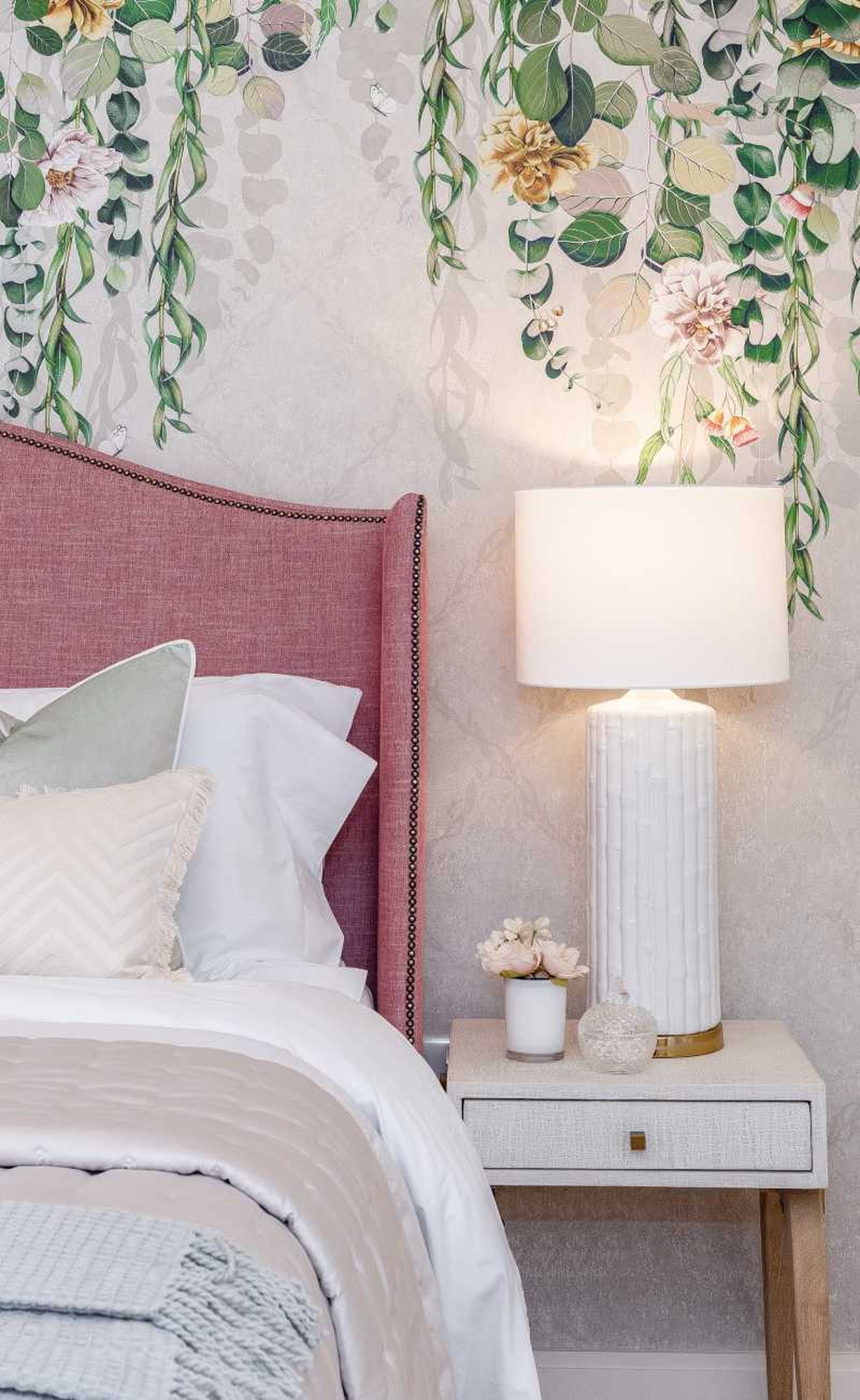 Dormitorio con papel pintado floral sencillo en el cabecero. Dormitorio con papel pintado floral sencillo en el cabecero.