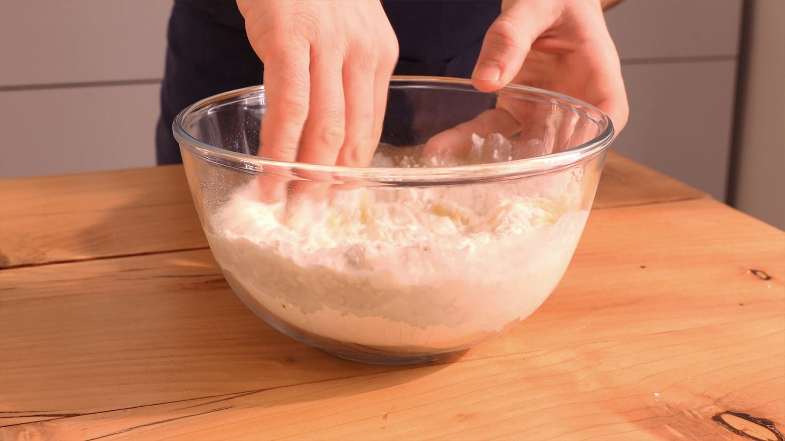 Amasa la mezcla de harina y agua hasta conseguir una textura suave y elástica, ideal para el pan casero Amasa la mezcla de harina y agua hasta conseguir una textura suave y elástica, ideal para el pan casero
