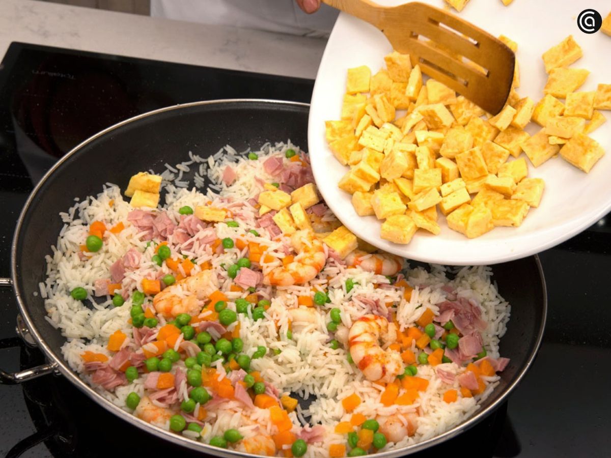 Saltea los langostinos, añade el arroz y mezcla el resto de ingredientes