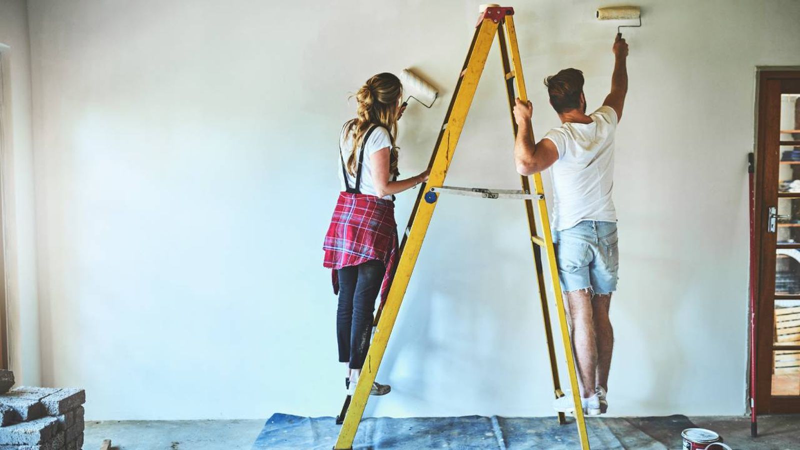 pareja en escalera pintando casa
