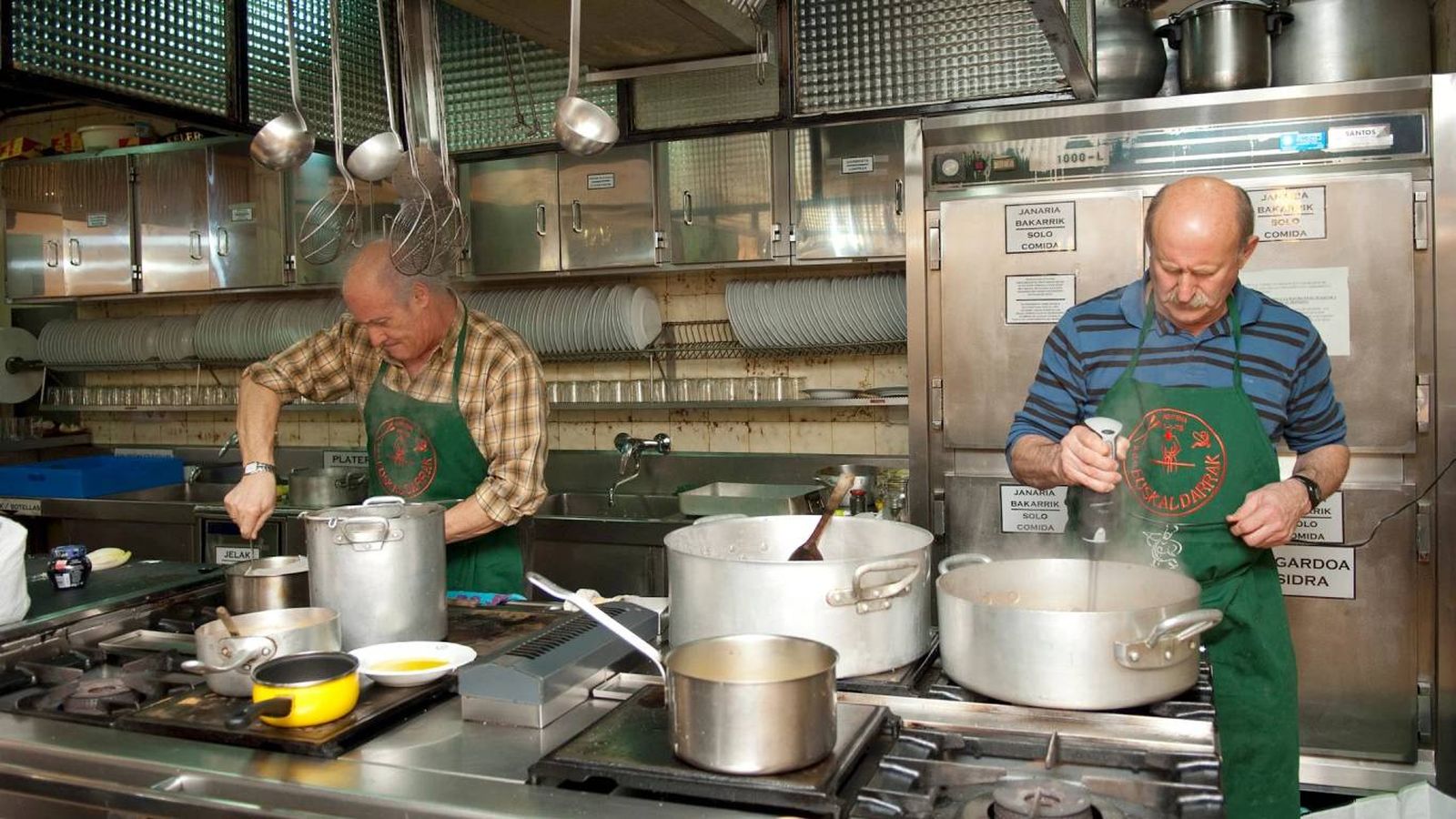Dos socios cocinando en una sociedad donostiarra: se cocina, se recoge y se comparte en comunidad.