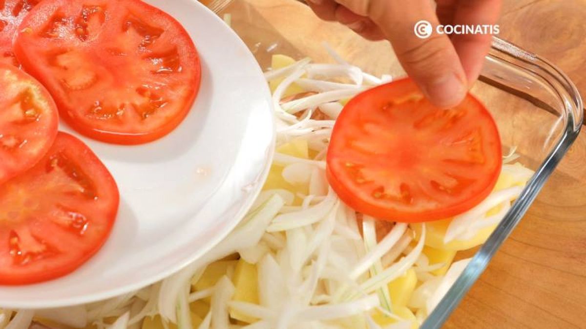 Reparte las patatas, el ajo, las cebolletas y el tomate sobre una fuente