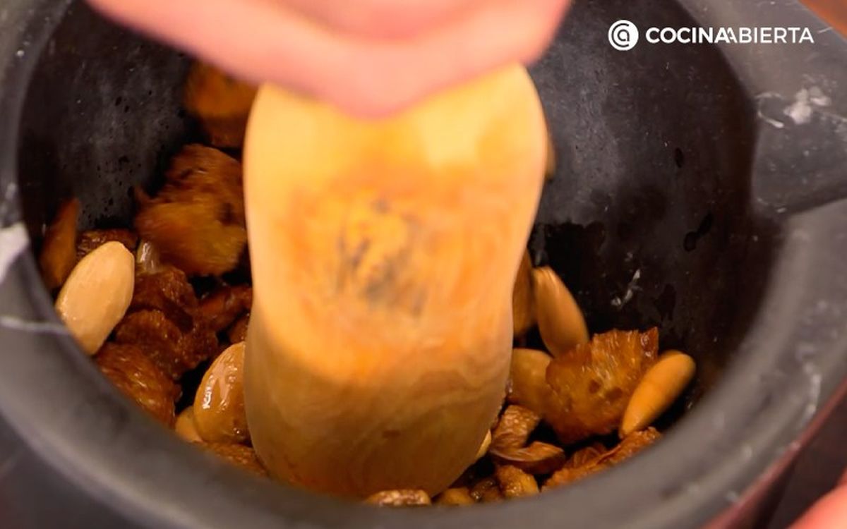 Tritura los ajos, las almendras y el pan tostado en un mortero