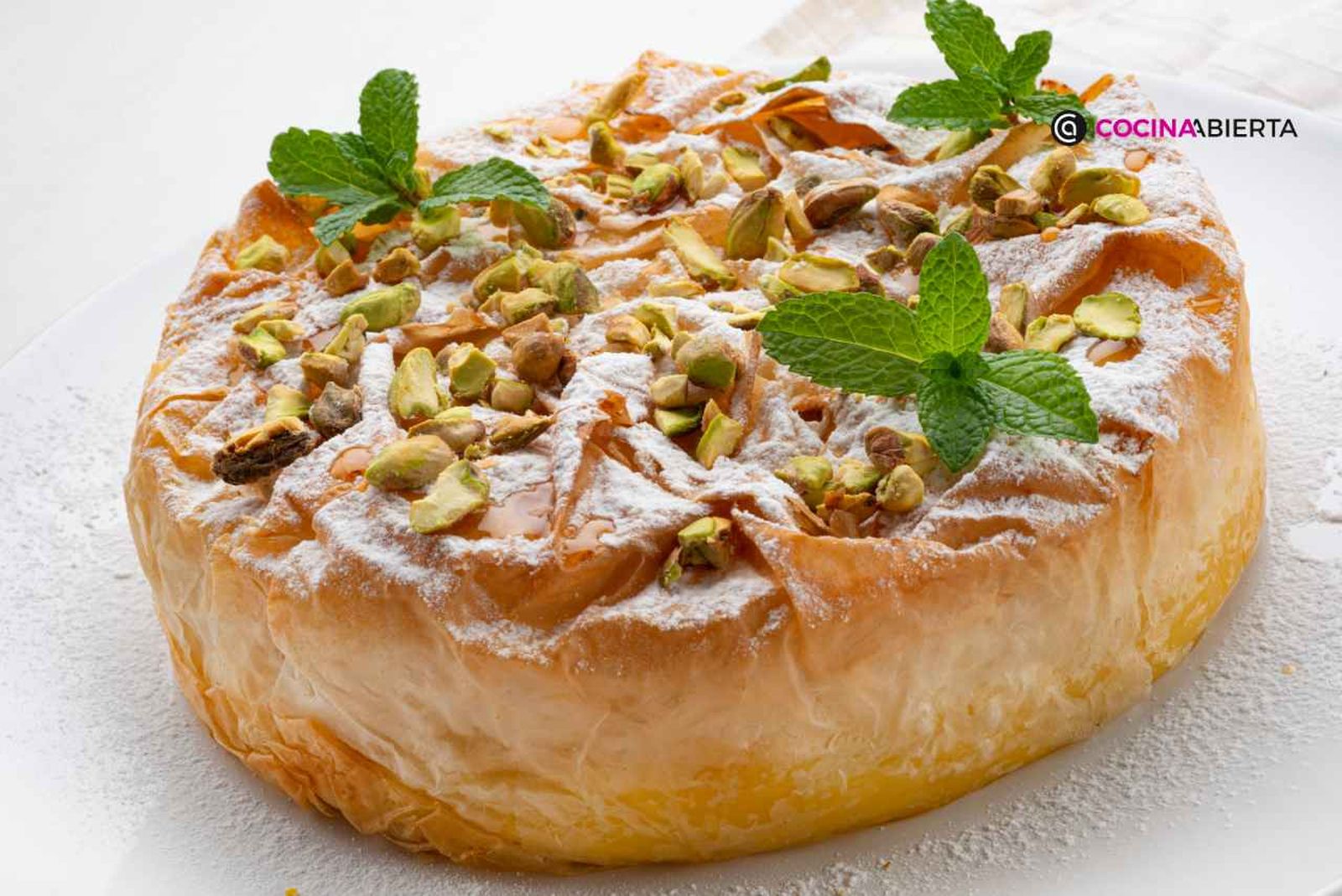 Tarta griega de pasta filo rellena de crema pastelera, con miel y pistachos