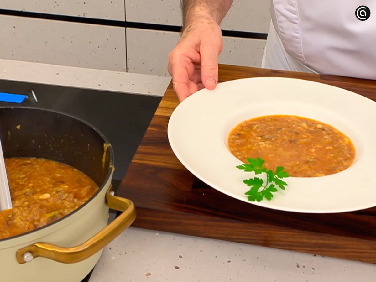 Decora la sopa de puerro, pan y bacalao con una hoja de perejil