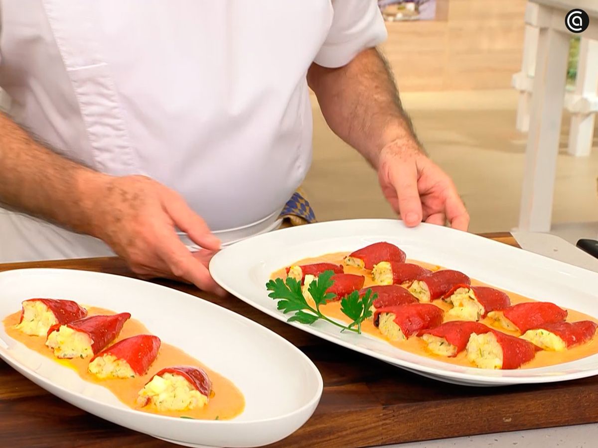 Coloca los pimientos rellenos de merluza y huevo encima de la salsa