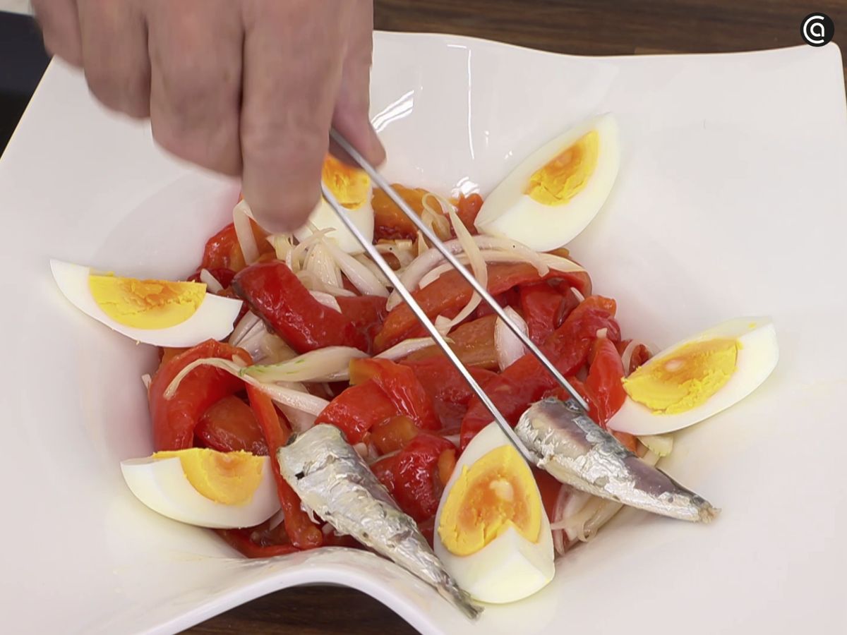 Sirve los pimientos con el huevo cocido y las sardinillas