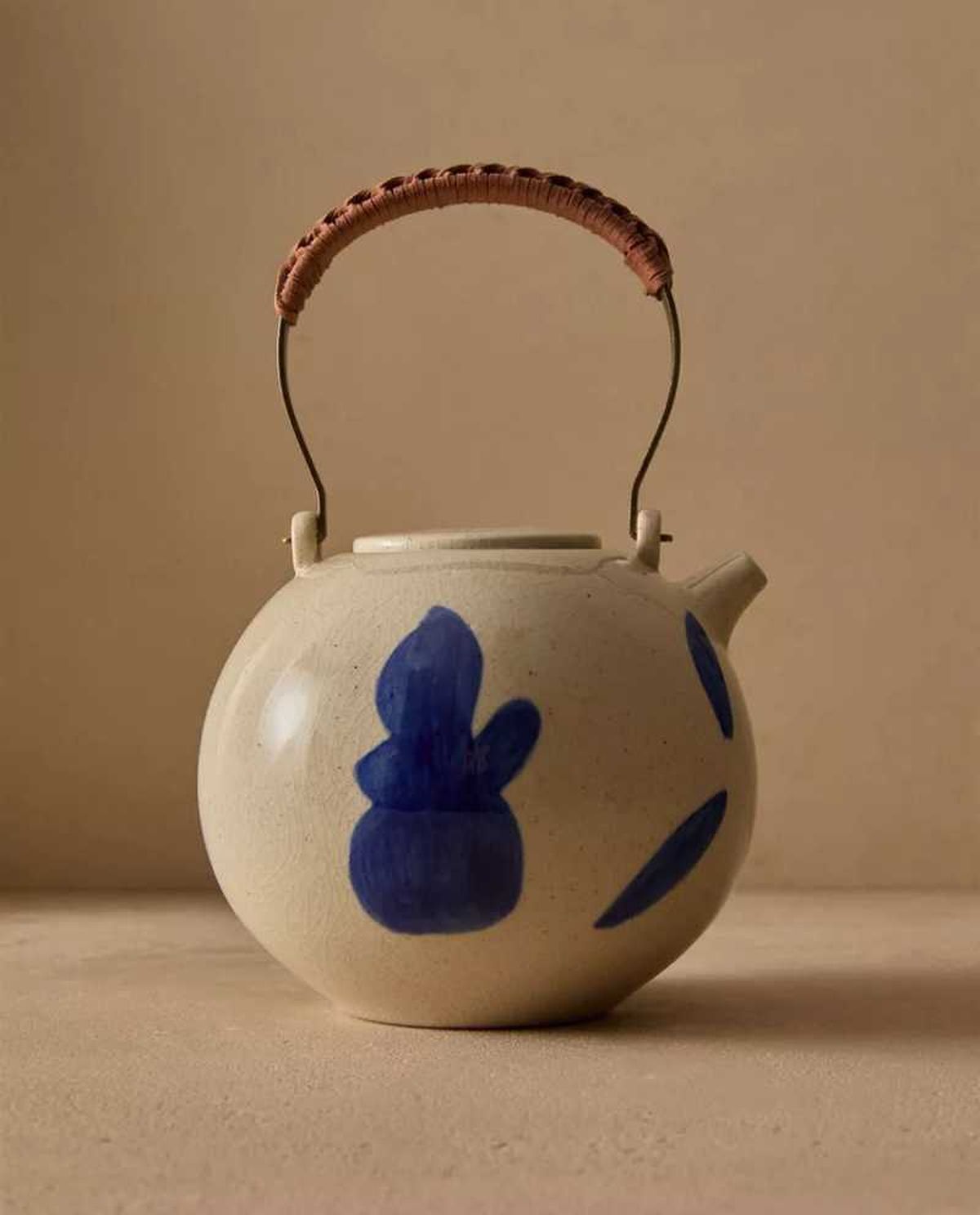 Tetera de cerámica con motivos pintados.