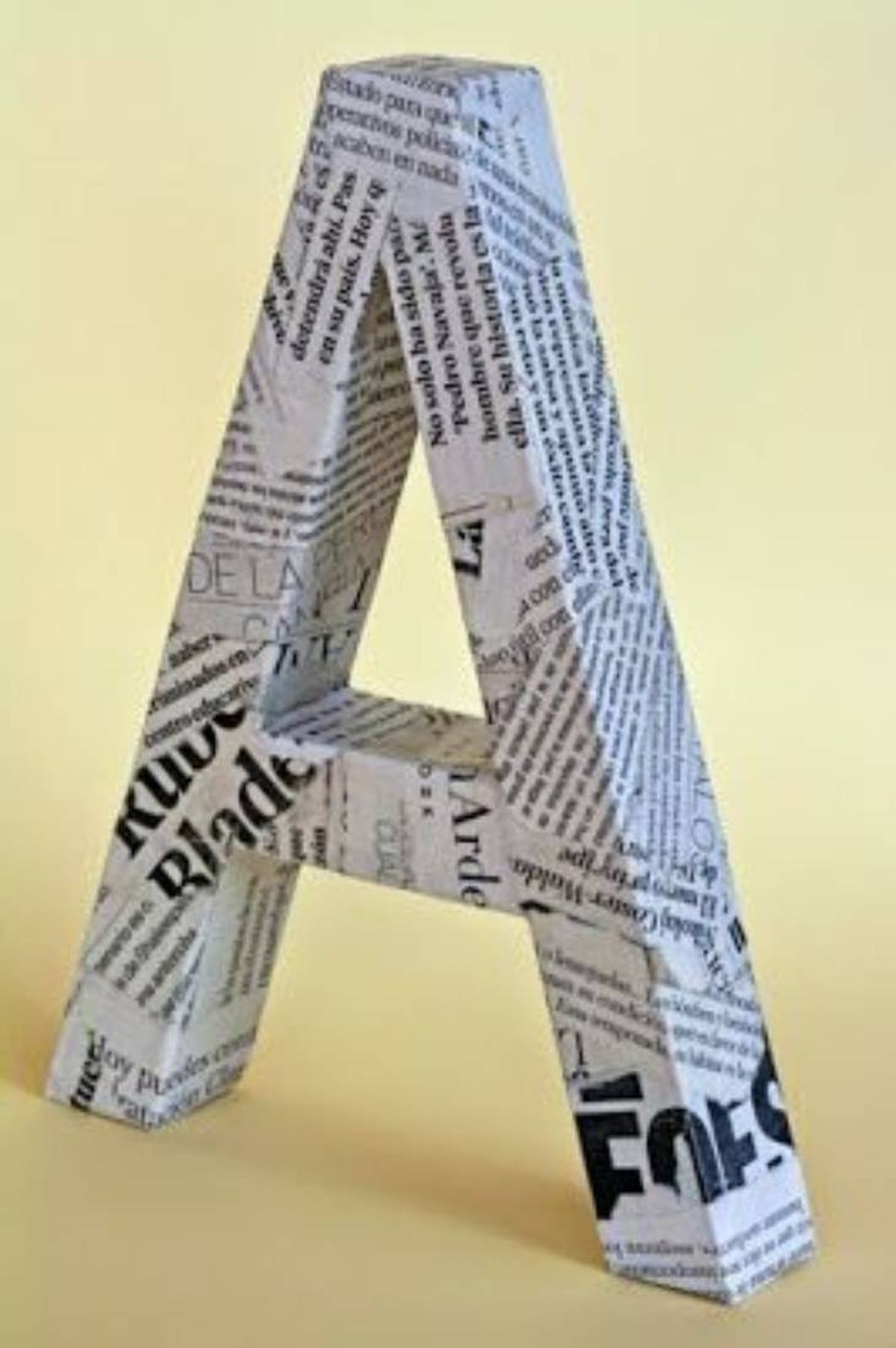 Letra A decorada con la técnica cartapesta con hojas de periódico.
