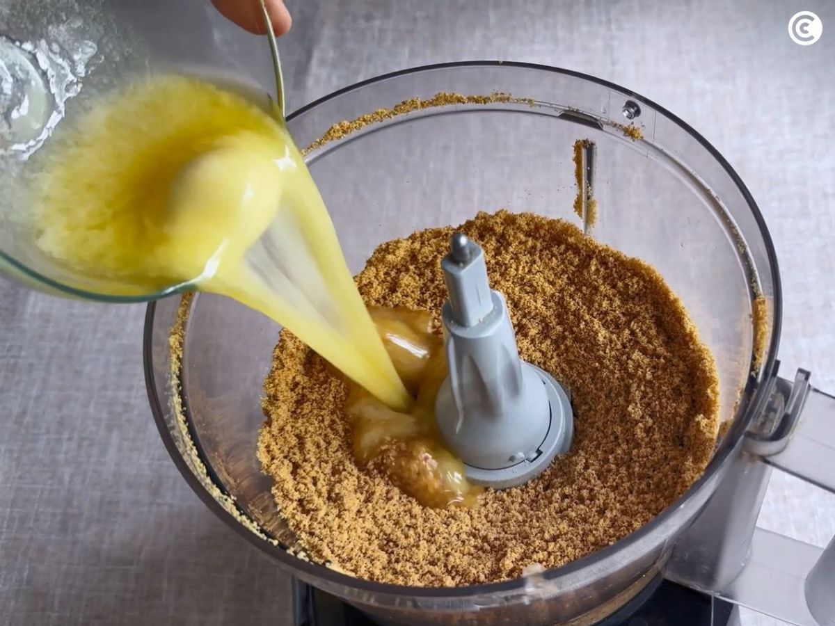 Mezclar galletas con mantequilla para la base de la tarta de dulce de leche