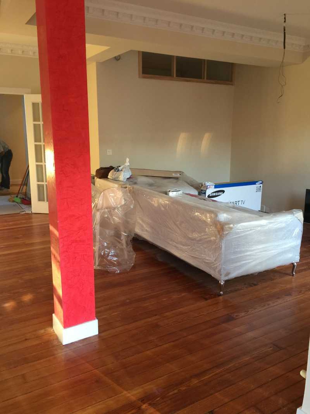 Salón con columna roja y sofá con patas cabriolé.