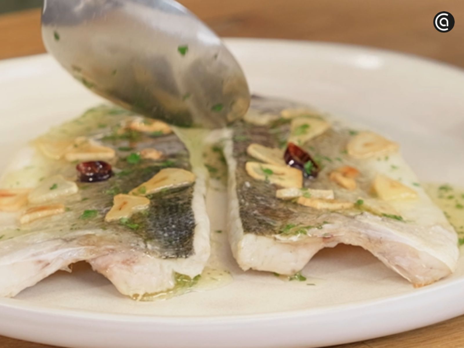 Liga la salsa de la bandeja y sírvela sobre la lubina antes de llevarla a la mesa.