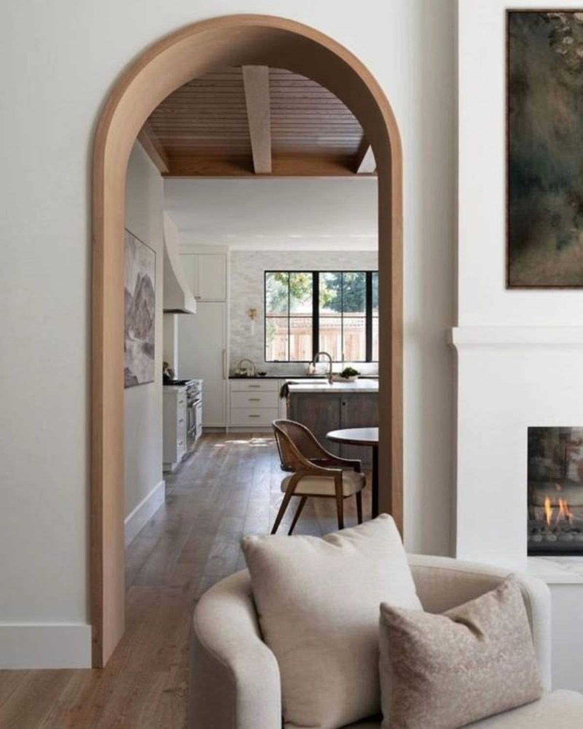 Cocina y salón divididos por arco decorativo de madera.