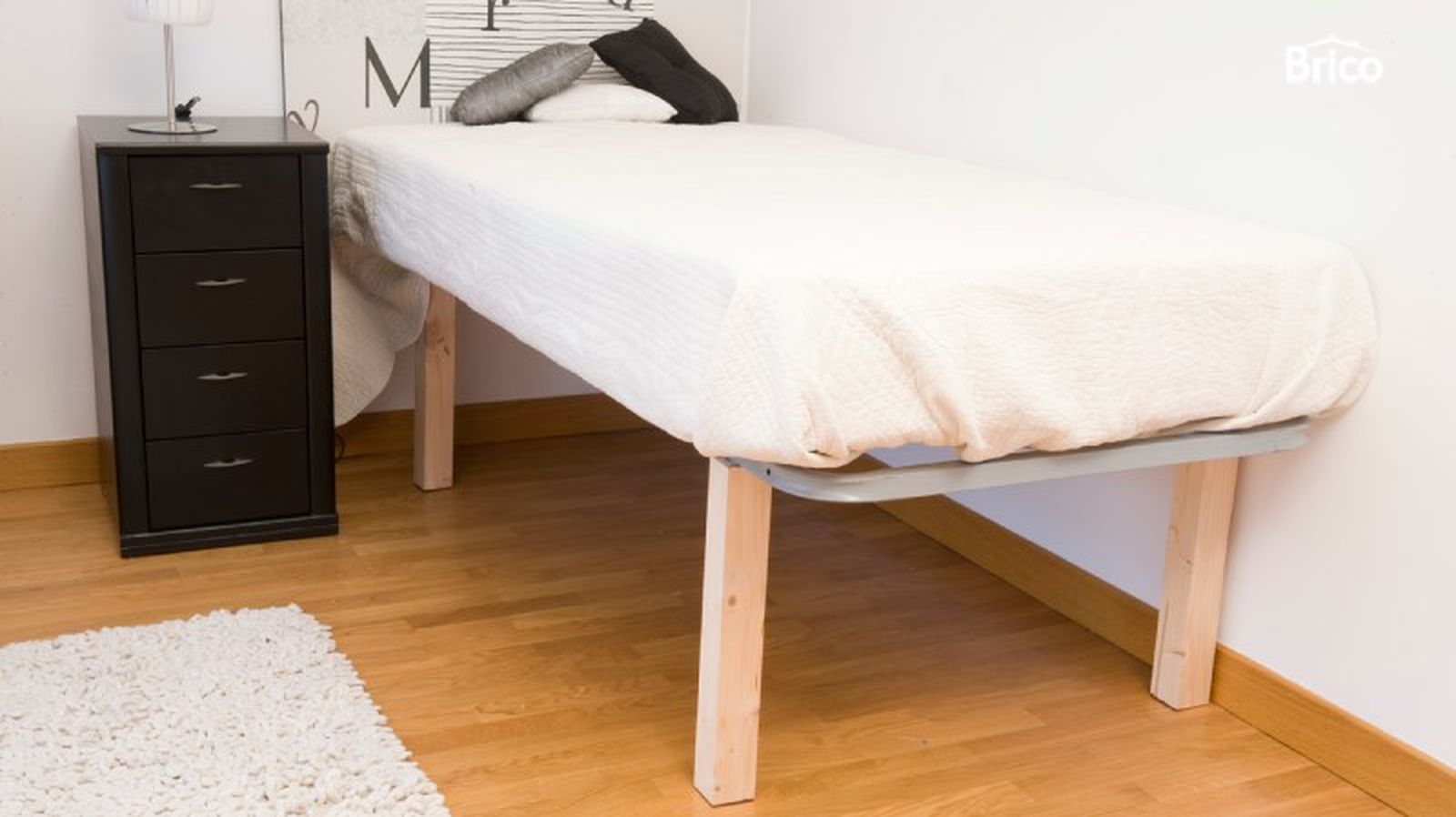 Una cama con patas de madera Una cama con patas de madera